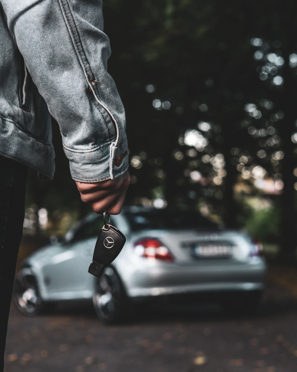Car keys being handed over beside the customer’s silver car