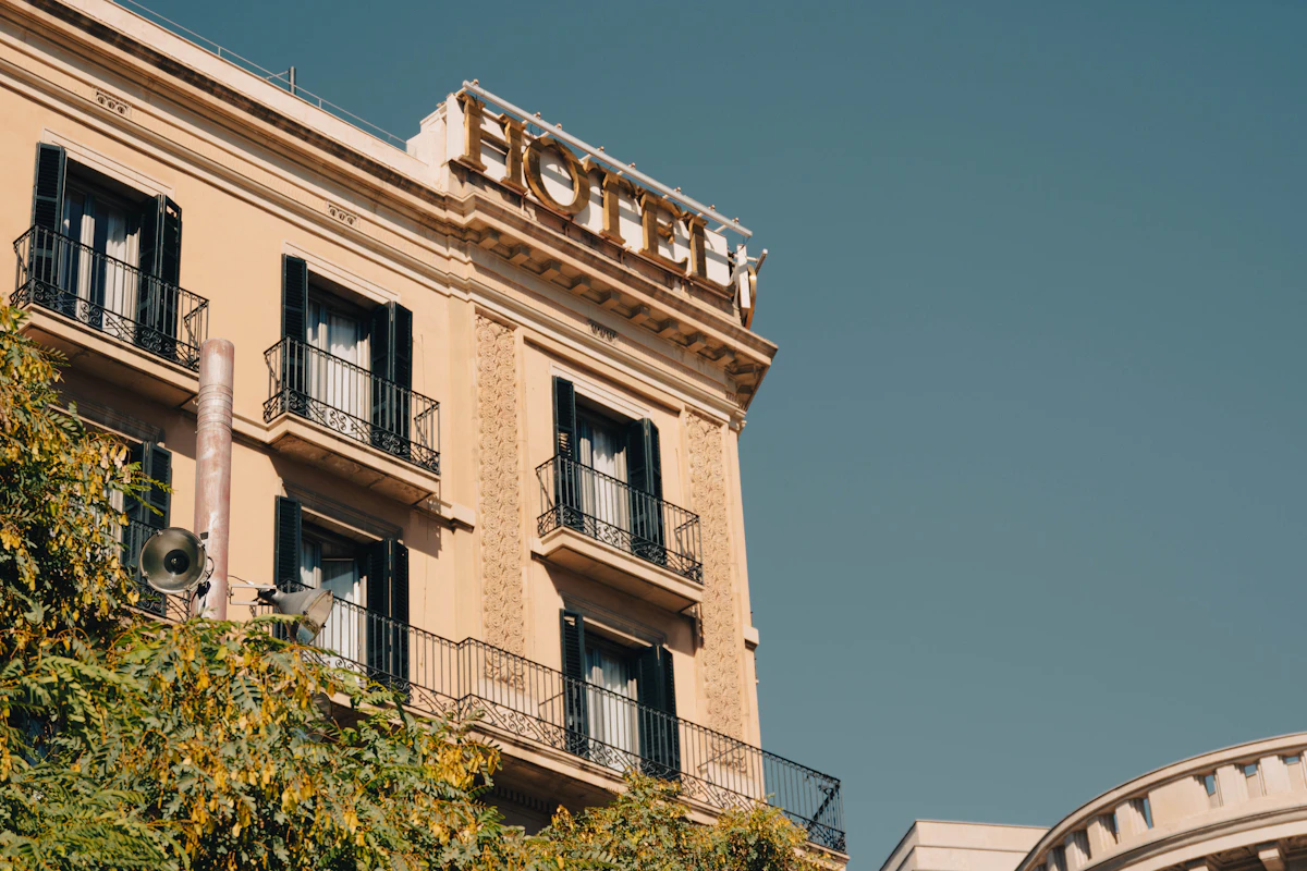A classic HOTEL sign above an ornate stone facade against a clear sky