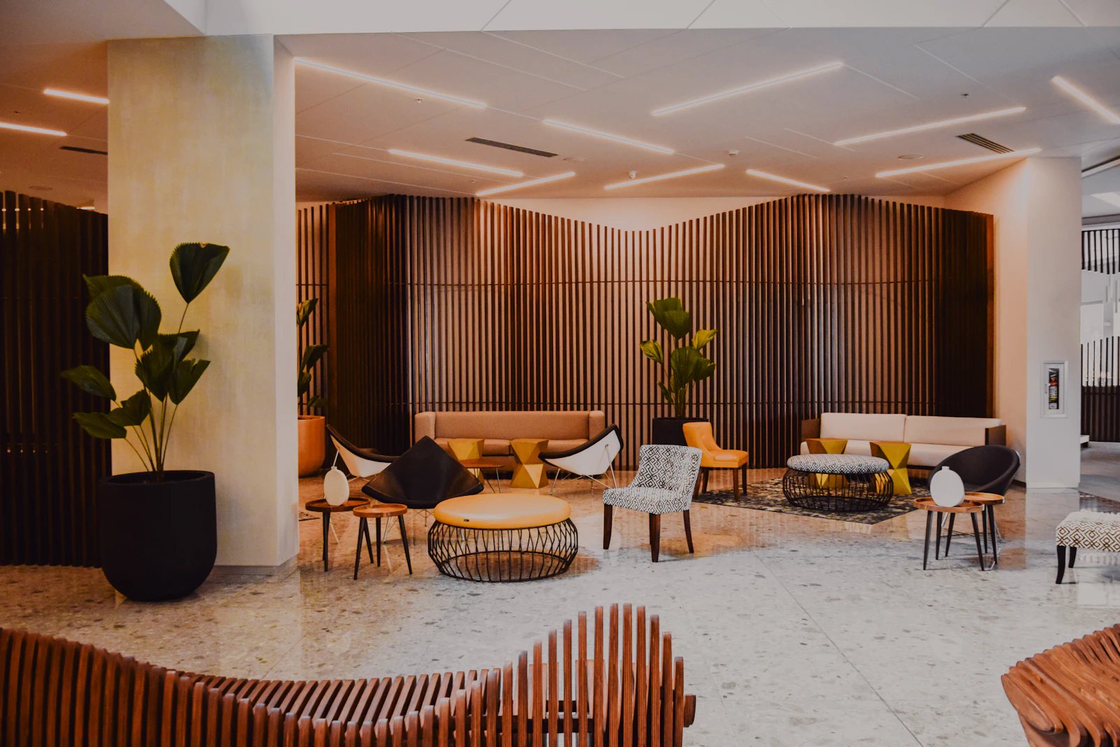 A modern hotel lobby with warm wood walls and designer furniture