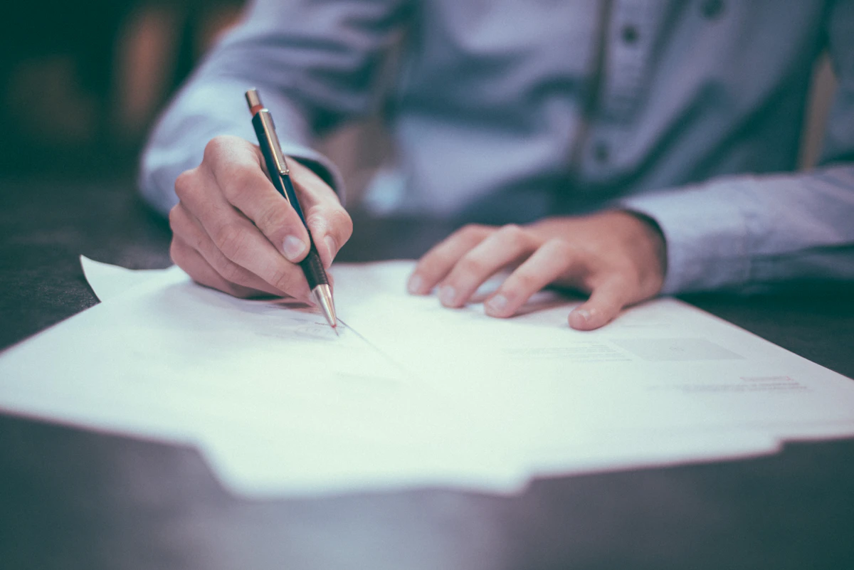 An attorney annotating legal documents with a pen at a desk