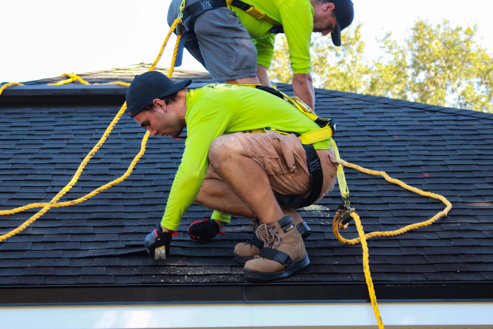 Two roofers at work on the roof of a suburban home