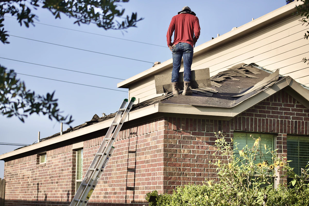 A roofer up on a residential roof checking the shingle field under an open sky